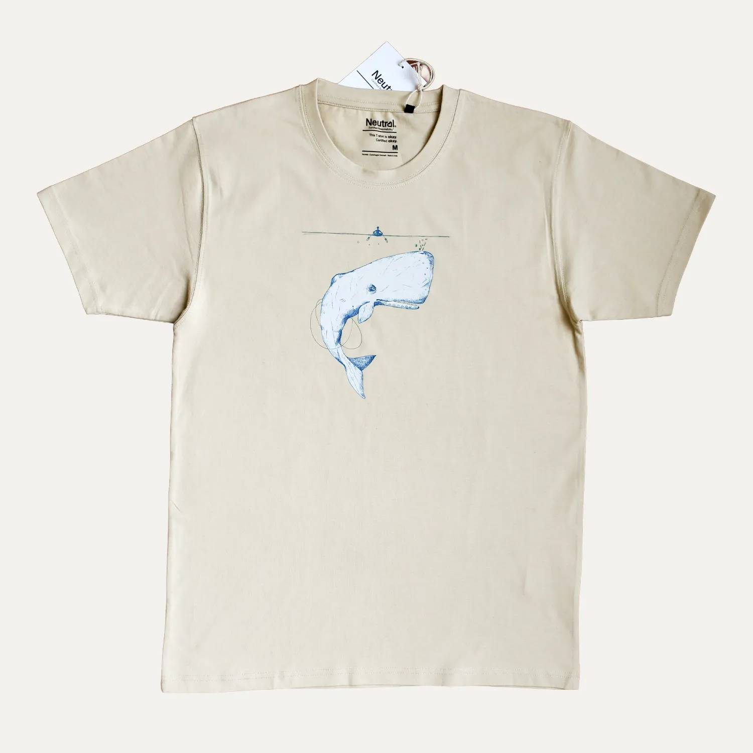 T-Shirt Balena . sabbia 2 Still life di t-shirt Balena color sabbia Collezione Navigazione con illustrazione originale di capodoglio sul fronte.