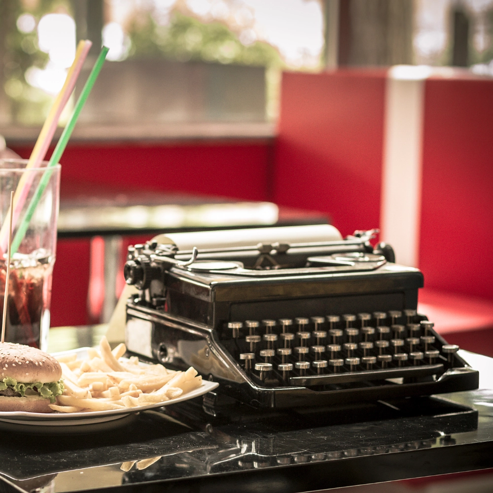 macchina-da-scrivere-anni-50 foto ambientata di una macchina da scrivere anni'50 sul tavolo di un fast food