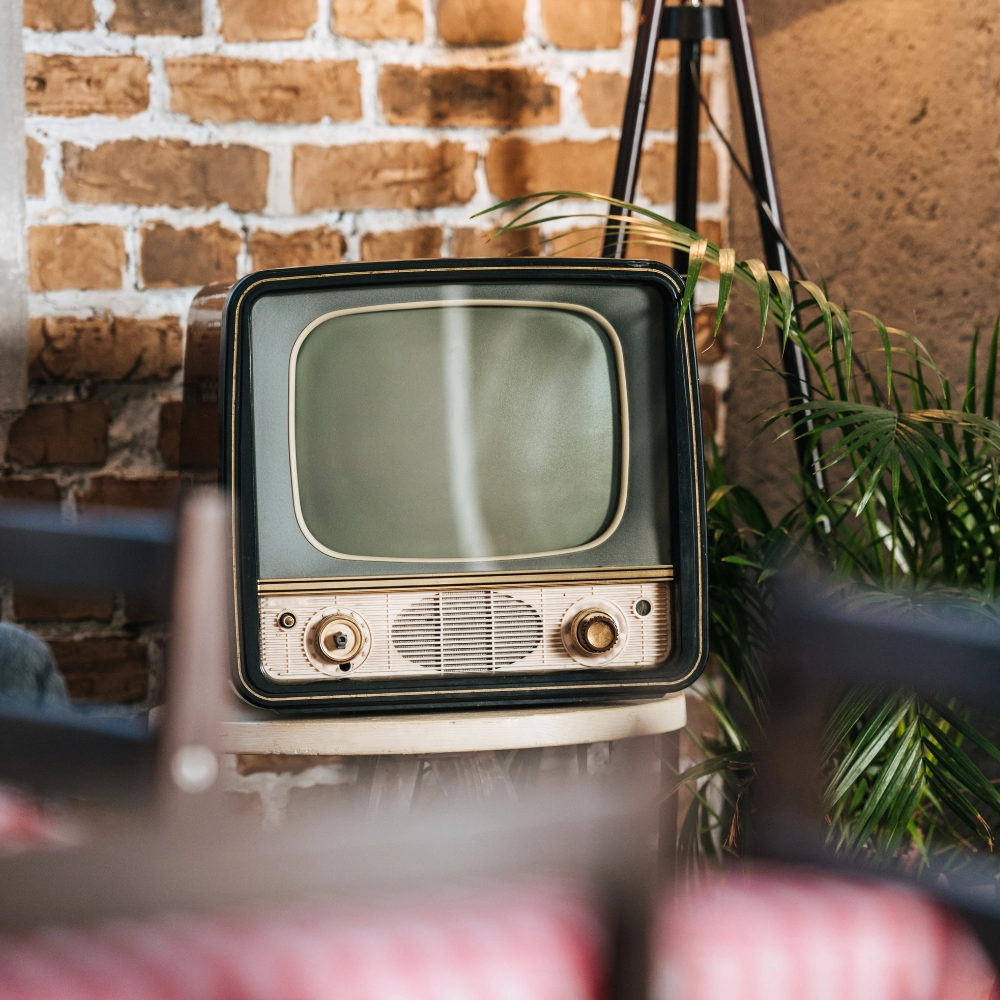 tv-anni-50 foto ambientata in un locale dal design vintage con focus su una tv degli anni '50 utilizzata come oggetto decorativo